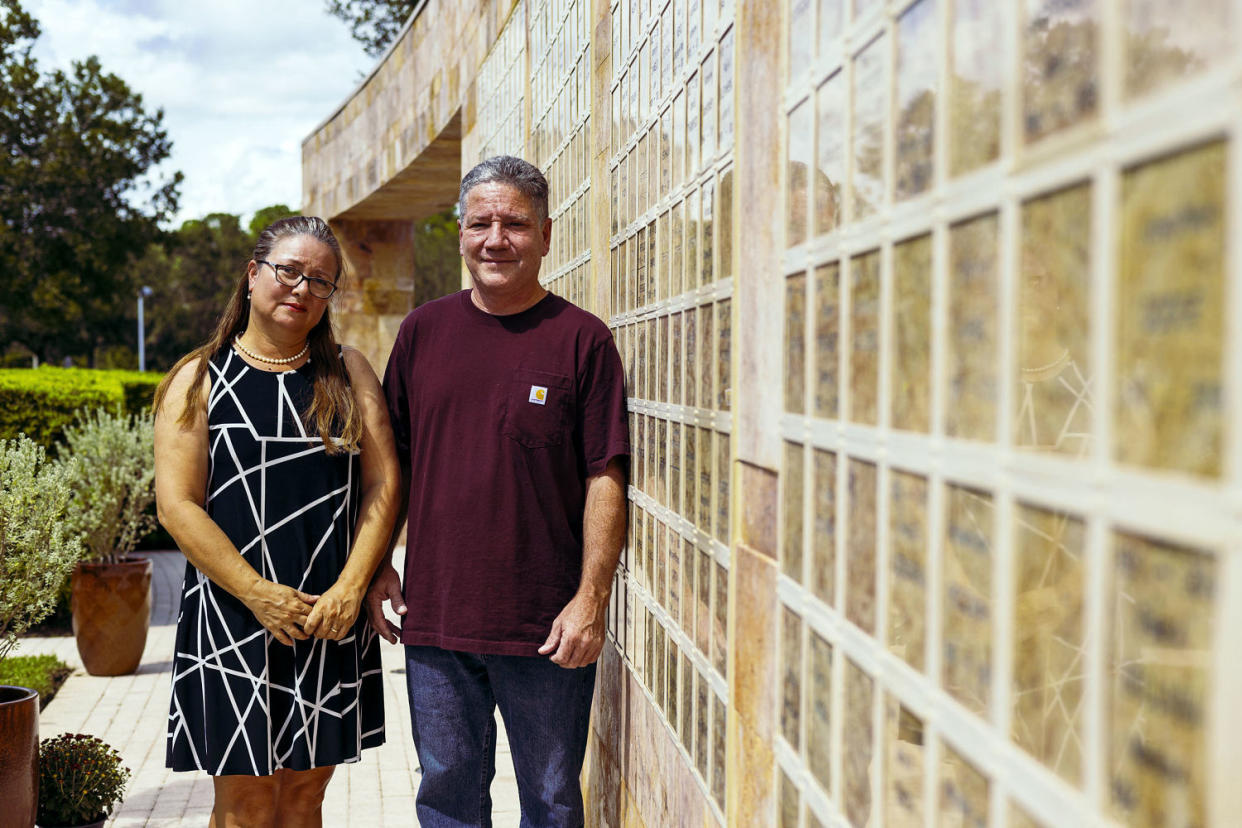 Elena Martinez and Jaime Mejia in front of a columbarium memorial where their son’s ashes are interred at St. Agnes Catholic Church in Naples, Fla. (Saul Martinez for NBC News)