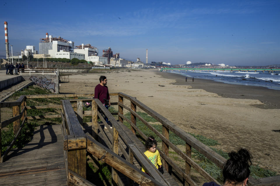 A family arrives to a beach near the Ventanas Smelter, of the state-owned company Codelco, on the first day of its closure in Quintero Bay in Puchuncavi, Chile, Wednesday, May 31, 2023. Chilean President Gabriel Boric announced in June 2022 the gradual closure of the world's leading copper producer in order to reduce the constant episodes of environmental pollution that affect the coastal communes near the furnace. (AP Photo/Esteban Felix)