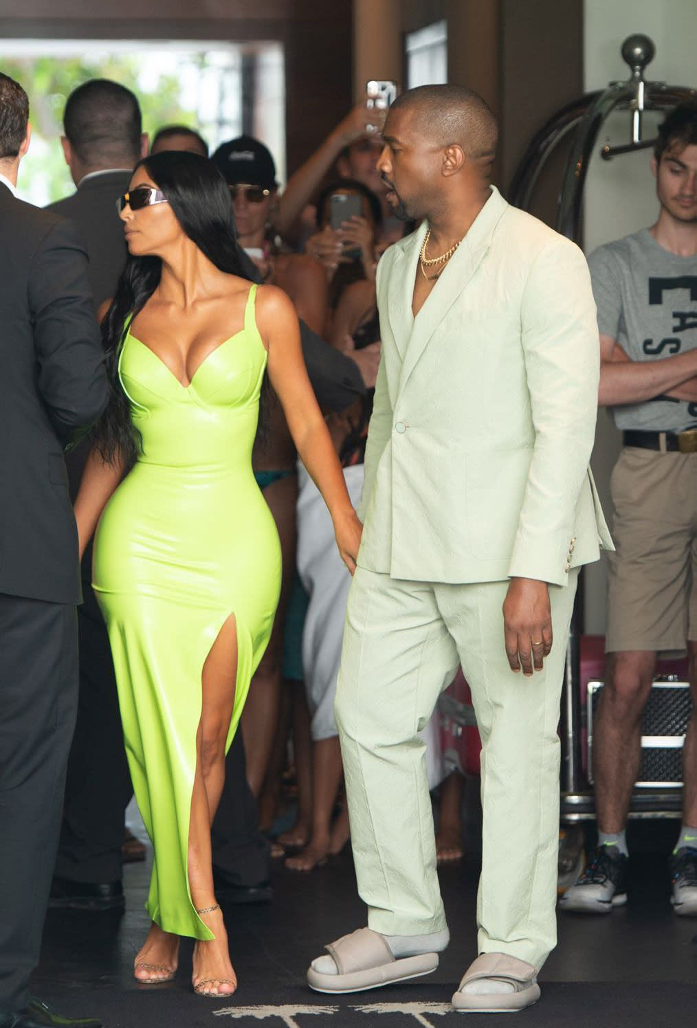 Kim Kardashian and Kanye West at 2 Chainz’s wedding to Kesha Ward. West is wearing a Louis Vuitton suit and Yeezy slides. (Photo: South Beach Photo/REX/Shutterstock