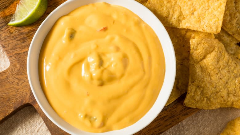 Queso, tortilla chips, and lime