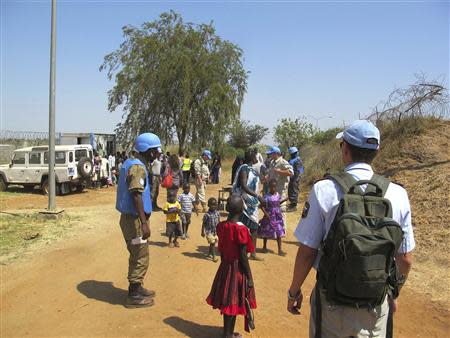 United Nation's peacekeepers guide civilians arriving outside the United Nations compound on the outskirts of capital Juba in South Sudan, in this December 16, 2013 handout from the United Nations Mission in South Sudan (UNMISS). REUTERS/UNMISS/Handout via Reuters