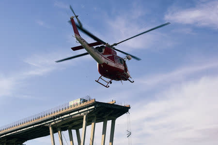 Fire fighters inspect from the helicopter the site of the collapsed Morandi Bridge in the port city of Genoa, Italy August 14, 2018. REUTERS/Massimo Pinca