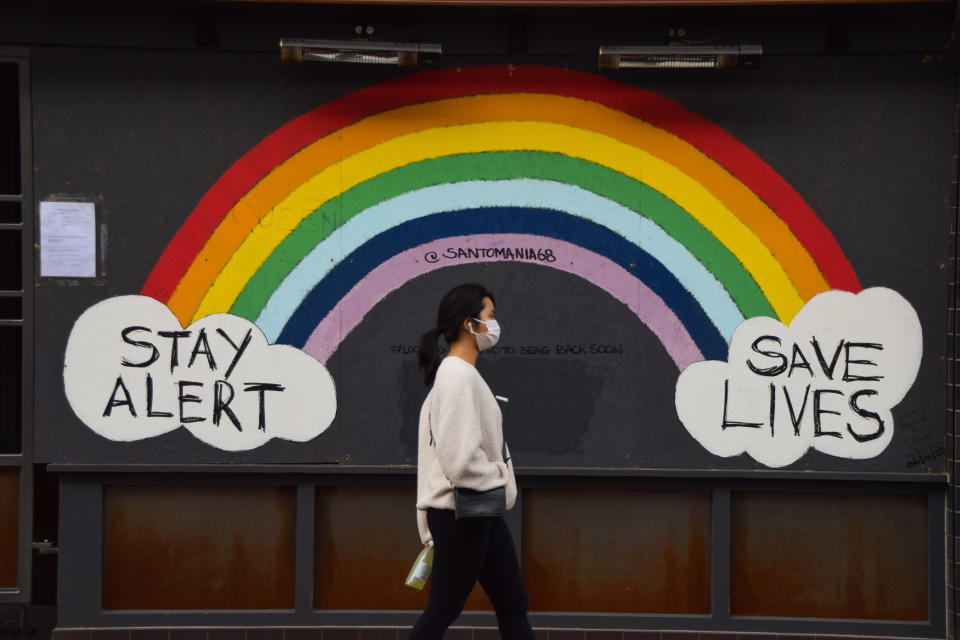  A woman wearing a face mask as a precaution walks past a Stay Alert, Save Lives rainbow sign in Soho. England is set to enforce a tough tier system once the lockdown ends on 2 December. (Photo by Vuk Valcic / SOPA Images/Sipa USA) 