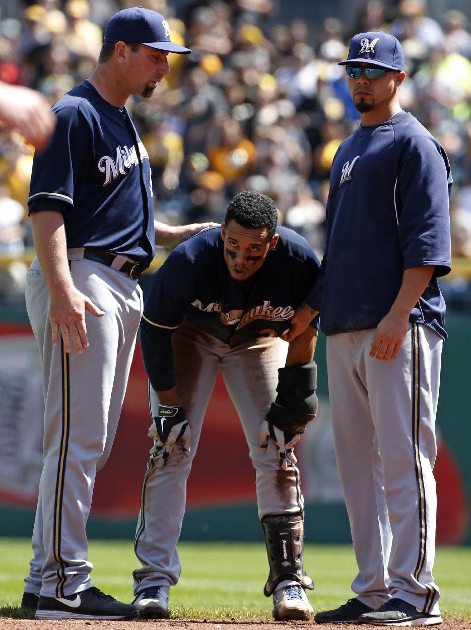 Milwaukee Brewers' Carlos Gomez, center, catches his breath after participating in a brawl with the Pittsburgh Pirates during the third inning of a baseball game in Pittsburgh, Sunday, April 20, 2014. Gomez and Pirates' Travis Snider were ejected from the game. (AP Photo/Gene J. Puskar)