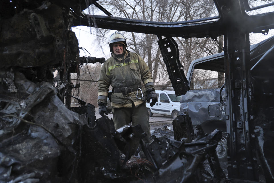 A firefighter examines a burned car after what Russian officials in Donetsk said was a shelling by Ukrainian forces, in Donetsk, the capital of Russian-controlled Donetsk region, eastern Ukraine, Thursday, Dec. 15, 2022. (AP Photo/Alexei Alexandrov)