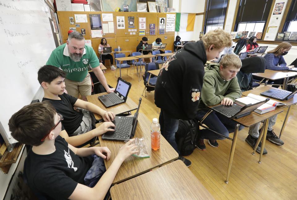 Eighth-grade teacher Shayne Porter helps Darion Asplund and Dorion Skaeski with an American history project in March at Wilson Middle School in Appleton.