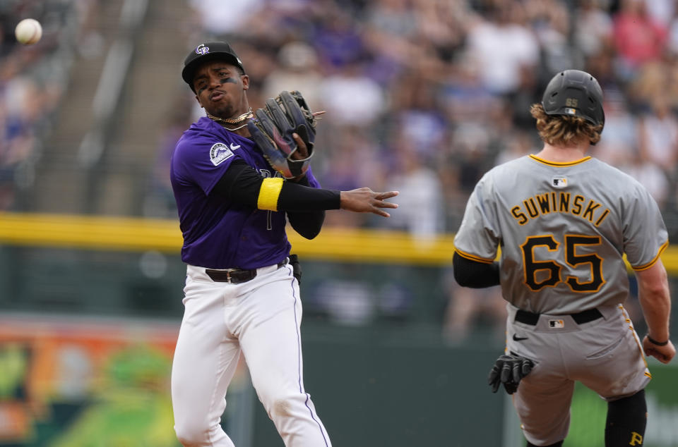 Colorado Rockies second baseman Adael Amador, left, throws to first base after putting out Pittsburgh Pirates' Jack Suwinski, right, at second on the front end of a double play hit into by Jared Triolo to end the top of the second inning of a baseball game Friday, June 14, 2024, in Denver. (AP Photo/David Zalubowski)