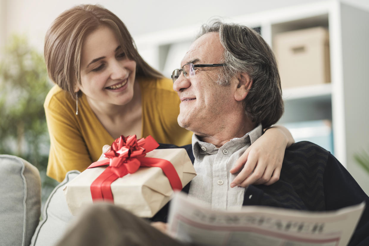 Young woman giving gift her father