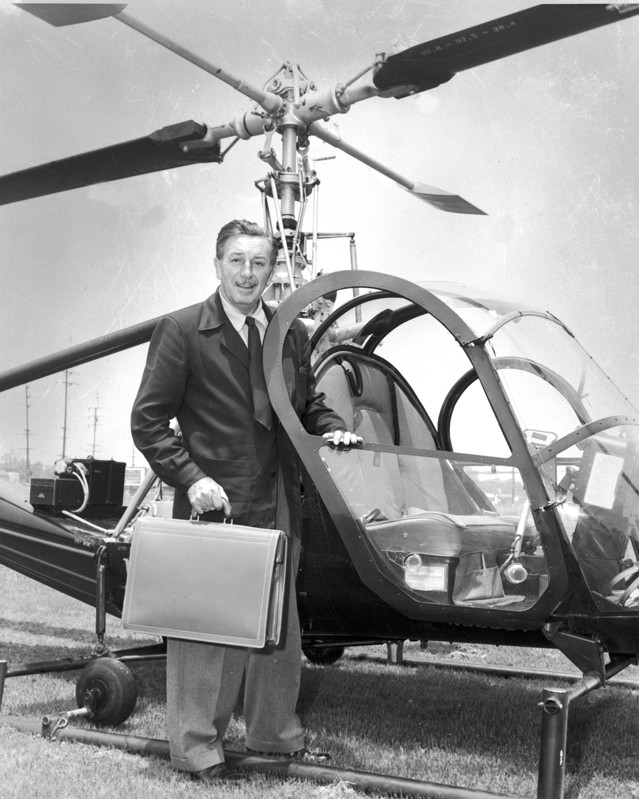 Walt Disney standing next to a helicopter bound for Disneyland