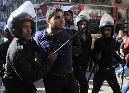 Riot police detain a man who was taking part in a protest against a new law in Egypt that restricts demonstrations, in downtown Cairo November 26, 2013. REUTERS/Amr Abdallah Dalsh