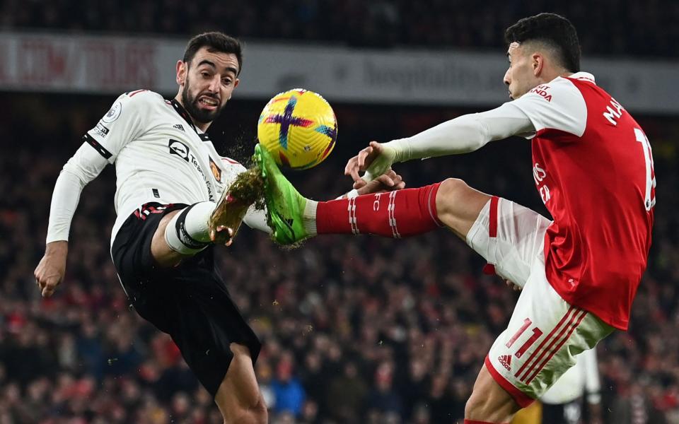 Manchester United's Portuguese midfielder Bruno Fernandes (L) vies with Arsenal's Brazilian midfielder Gabriel Martinelli (R) - AFP/Glyn Kirk