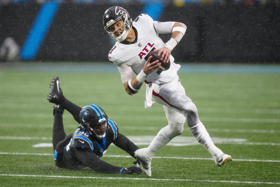 Atlanta Falcons quarterback Desmond Ridder runs past Carolina Panthers linebacker Marquis Haynes Sr. during the second half of an NFL football game Sunday, Dec. 17, 2023, in Charlotte, N.C. (AP Photo/Jacob Kupferman)