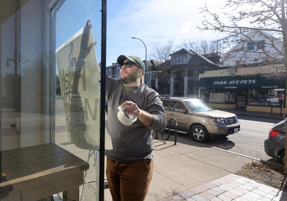 Ben Reiter, one of three owners of Homegrown and Handmade Market on Monroe Ave., works on the signage for the new store.