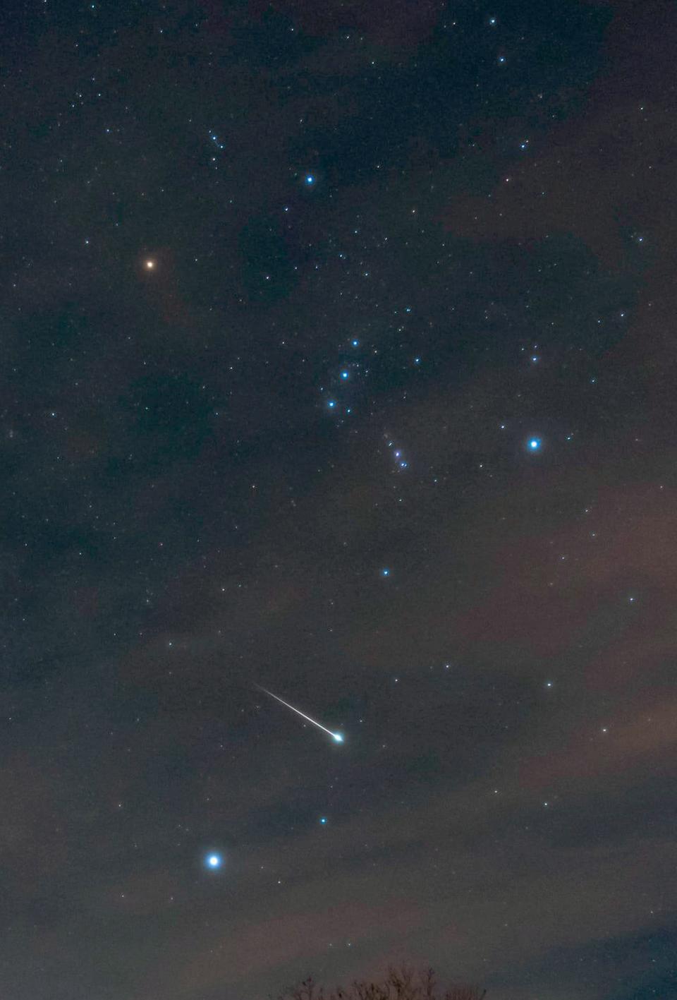 This bright Geminid meteor appeared over the author's backyard during the Geminid meteor shower the night of Dec. 13, 2020. The stars of the constellation Orion appear at top, and the bright star Sirius is below the meteor. The peak of the upcoming Geminid shower happens Monday night, Dec. 13.