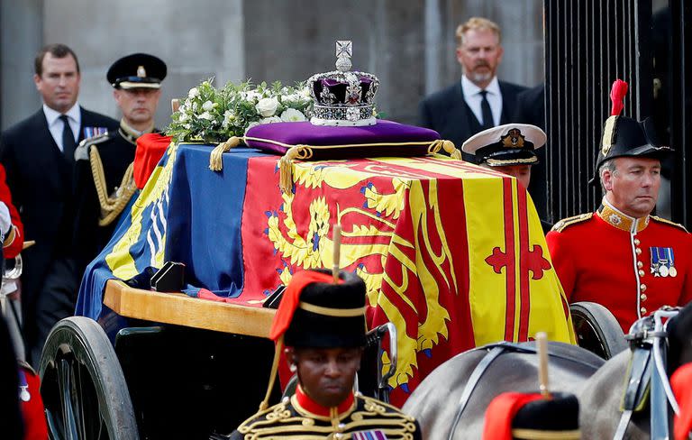 La corona del Estado Imperial se ve en el ataúd de la reina Isabel II, adornada con un estandarte real y la corona del estado imperial y tirada por un carro de armas de la artillería a caballo real de la tropa del rey, durante una procesión desde el Palacio de Buckingham hasta el Palacio de Westminster, en Londres el 14 de septiembre de 2022. (Photo by PETER NICHOLLS / POOL / AFP)