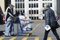 Shoppers walk in and out of a Meijer store for grocery shopping during the coronavirus outbreak as they wear masks and gloves in Arlington Heights, Ill., Thursday, April 9, 2020. (AP Photo/Nam Y. Huh)