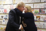 Britain's Prime Minister Boris Johnson is hugged during a General Election campaign trail stop in Wells, England, Thursday, Nov. 14, 2019. Britain goes to the polls on Dec. 12. (AP Photo/Frank Augstein, Pool)