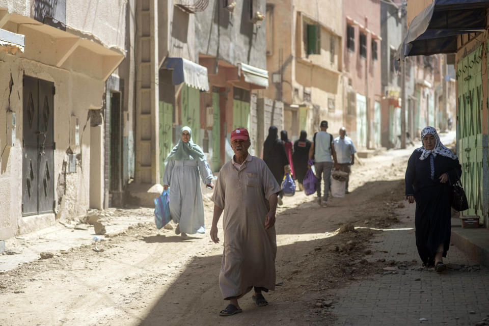 People walk and carry some of their possessions as they leave their town which was damaged by the earthquake, in Amizmiz, near Marrakech, Morocco, Sunday, Sept. 10, 2023. Towns and villages throughout Morocco's Atlas Mountains are mourning the dead and seeking aid after a record earthquake wreaked destruction throughout the region last week. (AP Photo/Mosa'ab Elshamy)