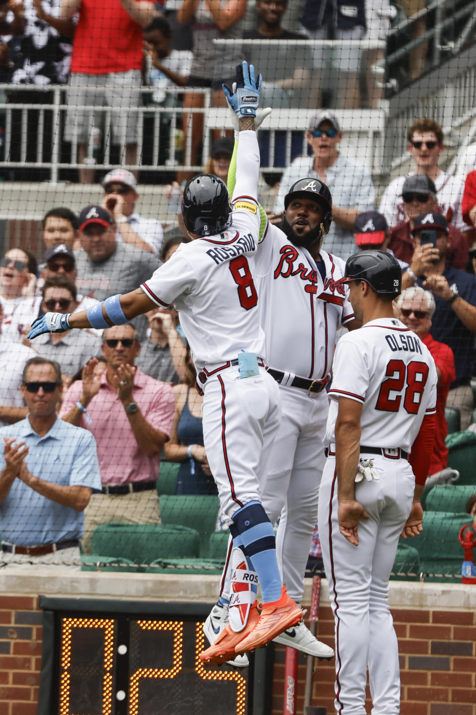 Atlanta Braves' Eddie Rosario (8) celebrates with Marcell Ozuna, center, and Matt Olson (28) after hitting a three-run home run in the second inning of a baseball game against the Colorado Rockies, Sunday, June 18, 2023, in Atlanta. (AP Photo/Butch Dill)