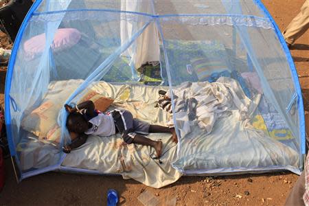 A displaced child plays on a mattress under a mosquito net laid in the open at Tomping camp, where some 15,000 displaced people who fled their homes are sheltered by the United Nations, near South Sudan's capital Juba January 7, 2014. REUTERS/James Akena