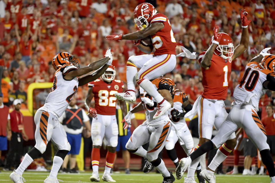 Kansas City Chiefs running back Darwin Thompson, center, is about to land on Cincinnati Bengals cornerback Darius Phillips, left, after trying to vault over Bengals safety Brandon Wilson, right, a during the second half of an NFL preseason football game in Kansas City, Mo., Saturday, Aug. 10, 2019. (AP Photo/Ed Zurga)