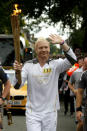 Former Olympian and Torchbearer Iwan Thomas carries the Olympic Flame.