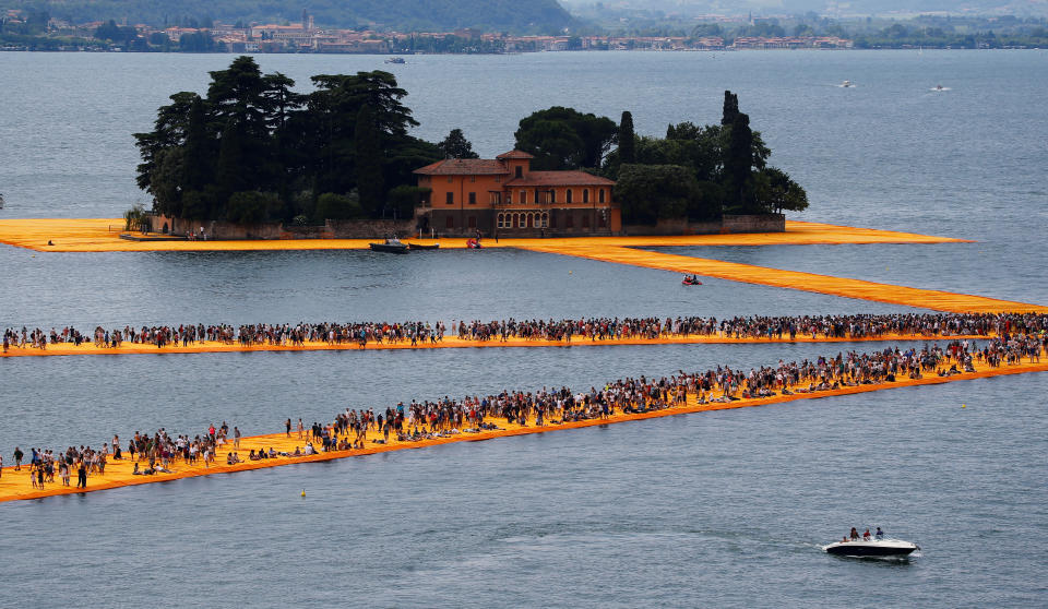 People walk on the installation 'The Floating Piers' by Bulgarian-born artist Christo Vladimirov Yavachev, known as Christo, at the installation's last weekend near Sulzano, northern Italy, July 2, 2016. REUTERS/Wolfgang Rattay