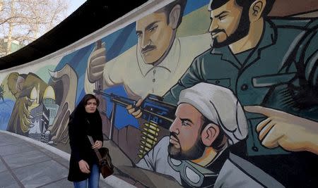 An Iranian woman walks past a revolutionary mural in Tehran, Iran, January 17, 2016. REUTERS/Raheb Homavandi/TIMA