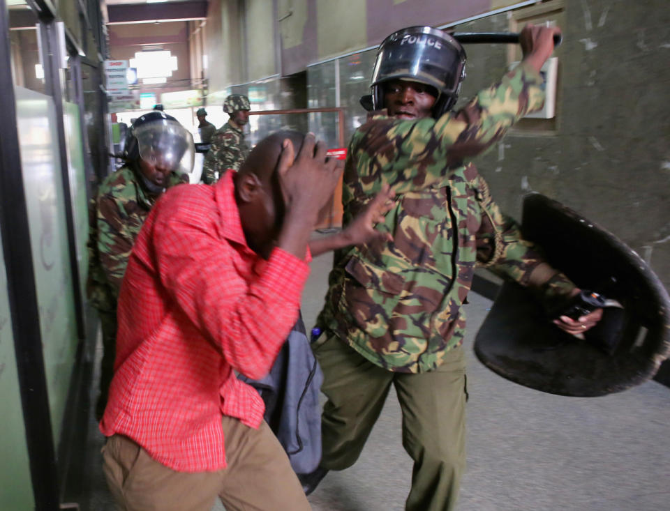 Policemen beat a protester inside a building during clashes in Nairobi, Kenya, May 16, 2016. (Reuters/Goran Tomasevic)