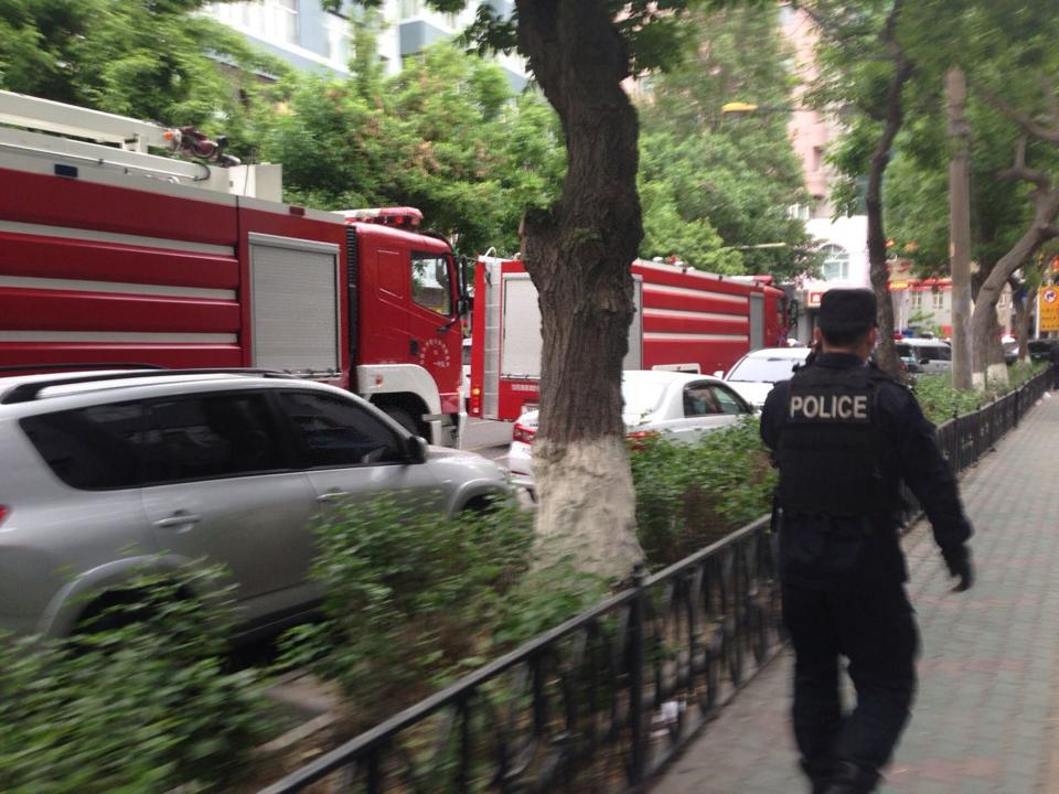 A policeman and fire-fighting trucks are seen near the site of an explosion, which has been cordoned off, in downtown Urumqi, Xinjiang Uighur Autonomous Region, May 22, 2014 in this photo distributed by China's official Xinhua News Agency. (REUTERS/Cao Zhiheng/Xinhua)