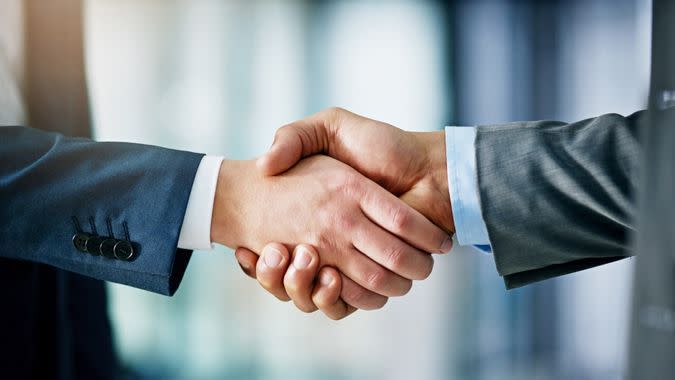 Closeup shot of two businessmen shaking hands in an office.