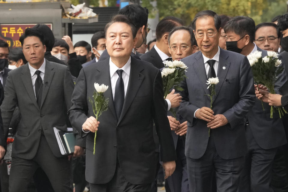 South Korean President Yoon Suk Yeol, second from left, arrives to pay tribute to victims of a deadly accident following Saturday night's Halloween festivities on a street near the scene in Seoul, South Korea, Tuesday, Nov. 1, 2022. (AP Photo/Ahn Young-joon)