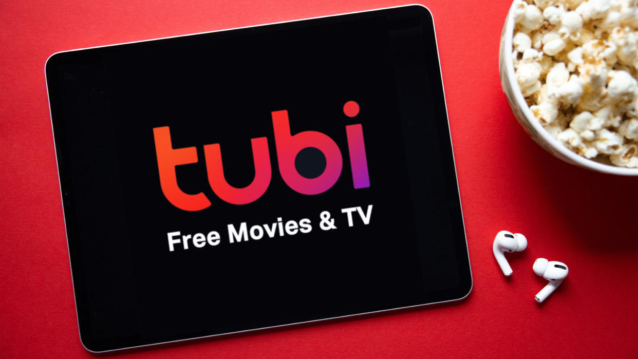  Tubi app on a tablet with popcorn and earbuds nearby. 