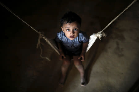 A Rohingya refugee child reacts to the camera while sitting on a cradle at the Balikhali camp in Cox's Bazar, Bangladesh, November 14, 2018. REUTERS/Mohammad Ponir Hossain