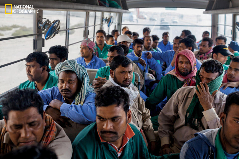 Starting at dawn, company buses haul foreign laborers between residential camps and work sites in Dubai. These workers are returning bleary-eyed to group dormitories.