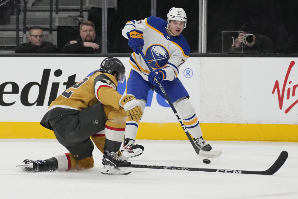 Buffalo Sabres right wing JJ Peterka (77) passes around Vegas Golden Knights defenseman Daniil Miromanov (42) during the first period of an NHL hockey game Monday, Dec. 19, 2022, in Las Vegas. (AP Photo/John Locher)