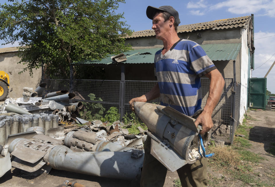 A farmer collects fragments of Russian rockets that he found on his field ten kilometres from the front line in the Dnipropetrovsk region, Ukraine, Monday, July 4, 2022. An estimated 22 million tons of grain are blocked in Ukraine, and pressure is growing as the new harvest begins. The country usually delivers about 30% of its grain to Europe, 30% to North Africa and 40% to Asia. But with the ongoing Russian naval blockade of Ukrainian Black Sea ports, millions of tons of last year’s harvest still can’t reach their destinations. (AP Photo/Efrem Lukatsky)
