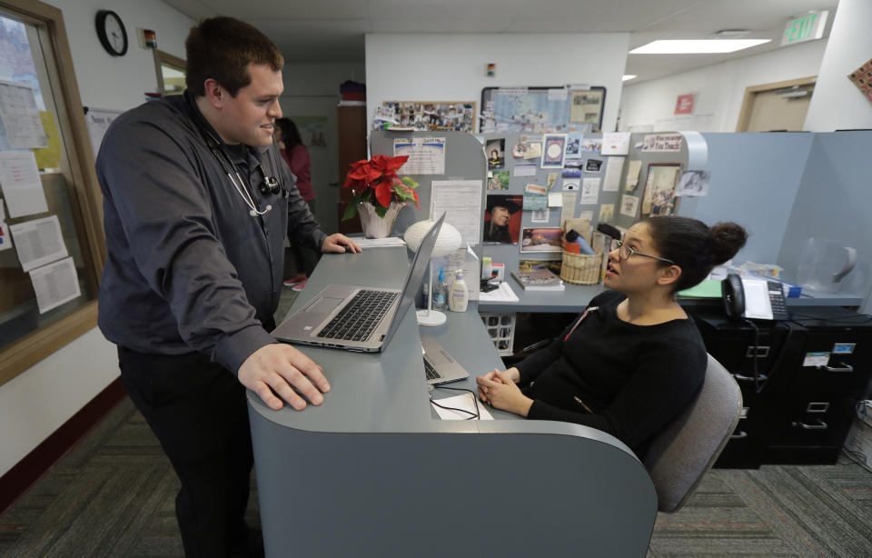 Dr. Alex Kivimaki, left, talks with Dr. Andrea Bachhuber-Beam, as they work at a clinic offering health care and other services operated by the Seattle Indian Health Board, Friday, Jan. 11, 2019, in Seattle. Fallout from the federal government shutdown is hurting hundreds of Native American tribes and entities that serve them. The pain is especially deep in tribal communities with high rates of poverty and unemployment, and where one person often supports an extended family. (AP Photo/Ted S. Warren)