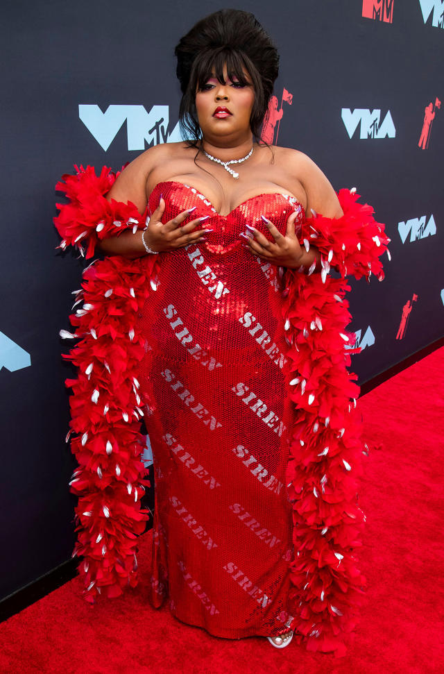 Lizzo stuns a ruby red body suit and a pair of well-worn Doc