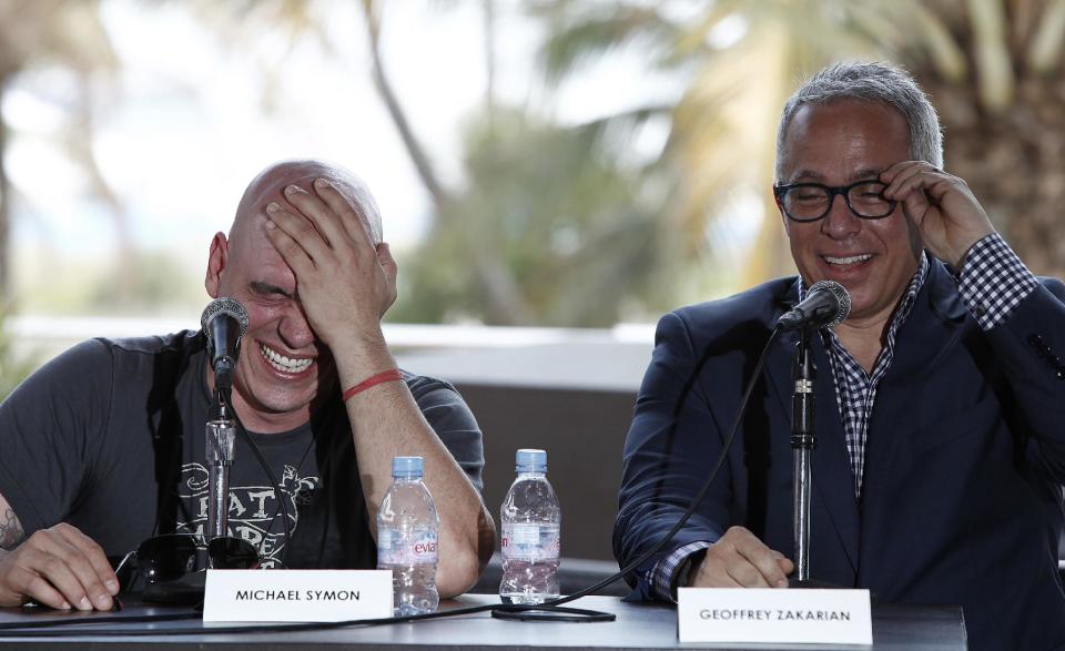 Celebrity chefs Michael Symon, left, and Geoffrey Zakarian laugh during a panel discussion about the experience of competing on TV cooking competitions, Saturday, Feb. 25, 2012 in Miami. (AP Photo/Carlo Allegri)