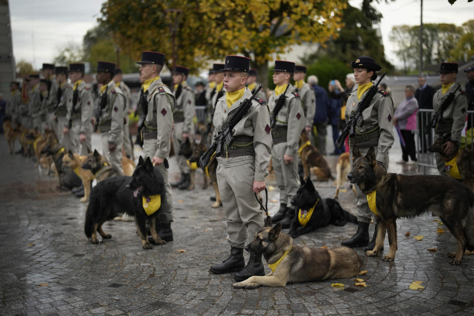 French soldiers with their dogs stand at attention during a ceremony in Suippes, eastern France, Thursday, Oct. 20, 2022. France inaugurated on Thursday its first memorial paying tribute to all "civilian and military hero dogs" in Suippes, in eastern France. The monument is located on a key World War I site, echoing the important role played by dogs in U.S. and European armies at the time.(AP Photo/Christophe Ena)