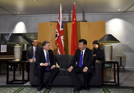 Chinese President Xi Jinping (R) talks with Britain's Foreign Secretary Philip Hammond after arriving for a four-day state visit at London's Heathrow Airport, October 19, 2015. REUTERS/Toby Melville