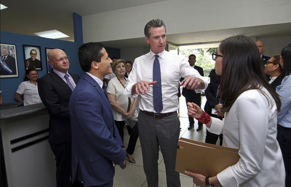 California Gov. Gavin Newsom, center, is welcomed at La Chacra Immigration Center in San Salvador, El Salvador, Monday, April 8, 2019. Gov. Newsom is hearing the stories of people who fled El Salvador and tried to reach the United States during his second day in the Central American country. (AP Photo/Salvador Melendez)