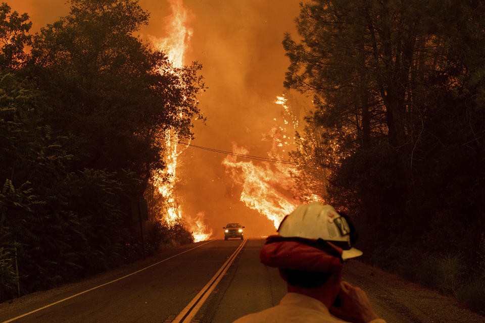 A car passes through flames on Highway 299 as the Carr Fire burns through Shasta, California.