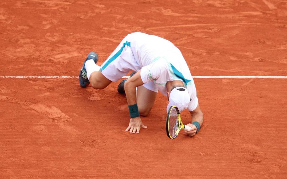 Facundo Bagnis of Argentina falls over against Daniil Medvedev during the Men's Singles First Round match on Day 3 of the French Open at Roland Garros on May 24, 2022 in Paris, France - Adam Pretty/Getty Images