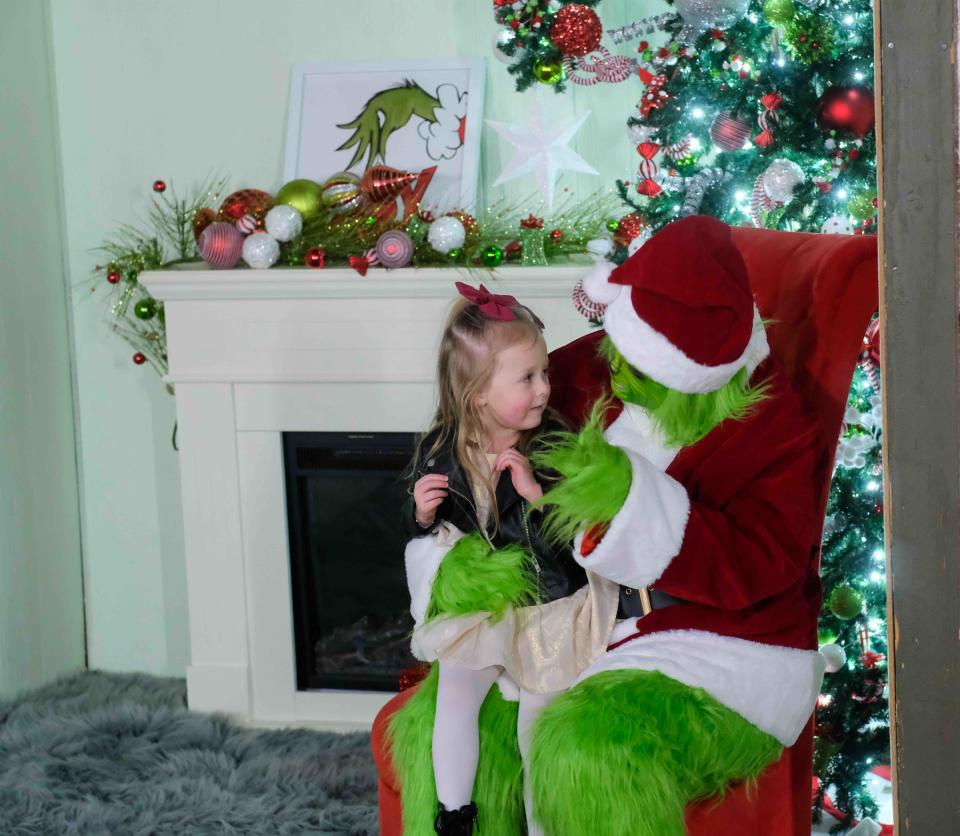 The Grinch shows that he is not such a mean one to young Leilani Cardenas at the Amarillo Botanical Gardens  Thursday during its Christmas in the Garden event.