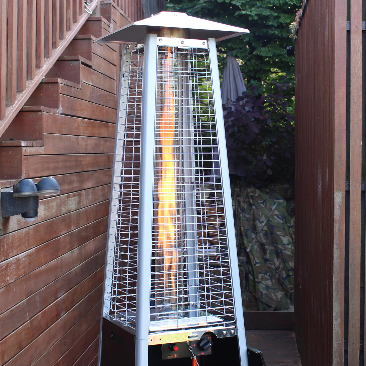  The Outsunny 11.2kw Pyramid Gas Patio Heater being unboxed and tested on a wooden deck 