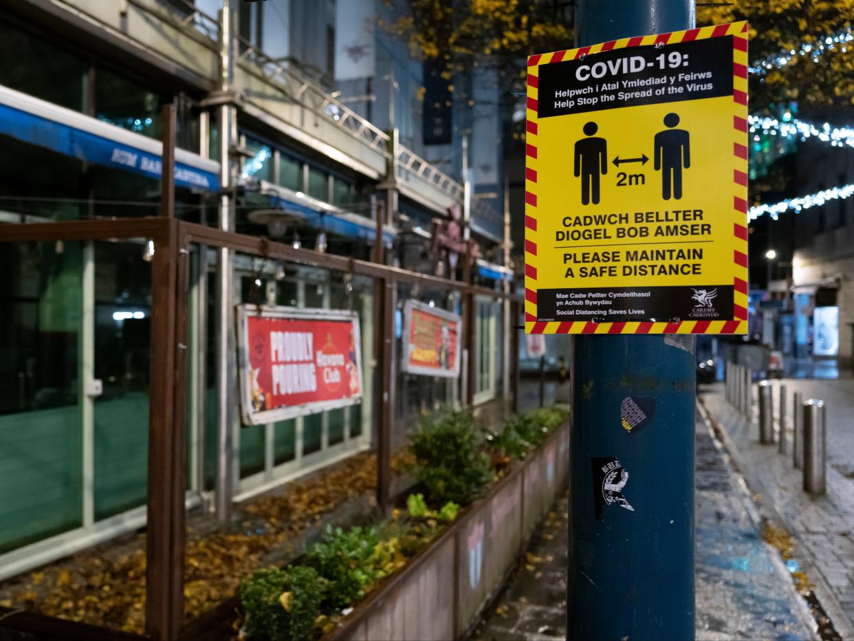 A yellow COVID-19 warning sign outside a bar in Cardiff, Wales (Getty Images)