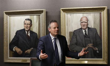 Bank of Canada Governor Stephen Poloz, standing in front of portraits of former governors James Coyne (L) and Louis Rasminsky, takes part in an interview with Reuters in Ottawa December 17, 2013. REUTERS/Chris Wattie