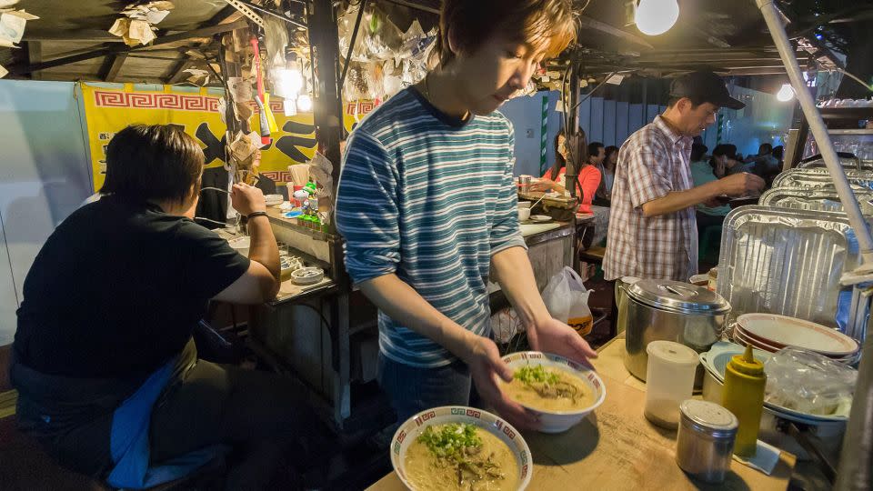 A vendor prepares local Hakata-style pork broth ramen at a Fukuoka yatai. - Hemis/Alamy Stock Photo